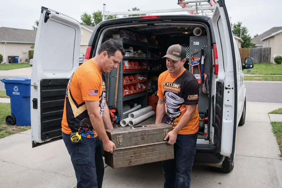 Two service professionals unloading a toolbox from their work van